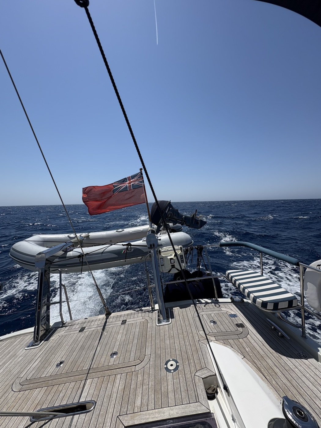 The yacht's stern and tender during an open-water passage